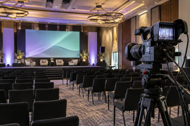 Broadcast camera, presentation screen and lighting in a conference venue